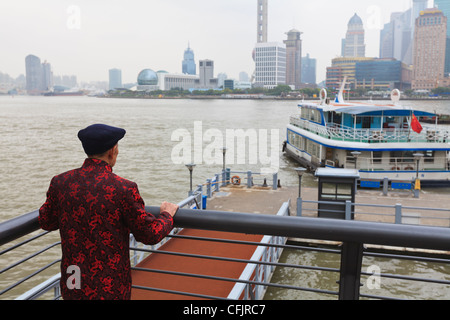 Un uomo la visione di traghetti che attraversano il fiume Huangpu, Shanghai, Cina e Asia Foto Stock