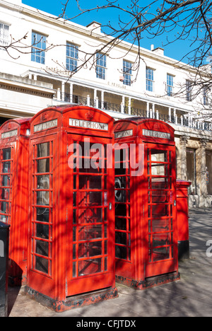 Quattro cabine telefoniche rosse e una casella di posta nel lungomare pedonale in regency città di Cheltenham, Gloucestershire Foto Stock