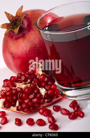 Fresche e mature e melograno succo in vetro Foto Stock