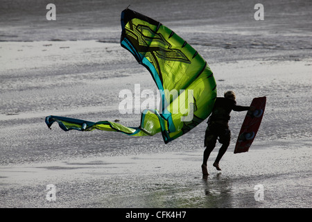 Kite surfer lotte contro il vento sulla spiaggia di Newgale Sands, Pembrokeshire, Galles Foto Stock