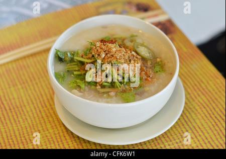 In stile asiatico zuppa di riso con erbe aromatiche in una ciotola Foto Stock