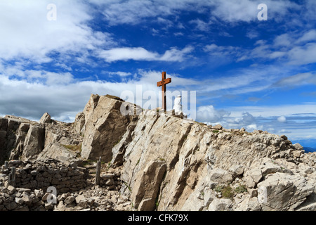 Vecchia trincea e croce nel Monte Castellazzo, Passo Rolle. Il Trentino, Italia Foto Stock