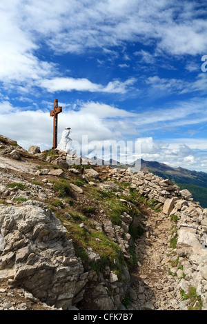 Vecchia trincea e croce nel Monte Castellazzo, Passo Rolle. Il Trentino, Italia Foto Stock