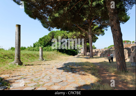 Ostia Antica. Lazio. L'Italia. Vista lungo il decumano superiore massimo o il Decumanus Maximus pavimentato con antiche pietre di basalto. È Foto Stock