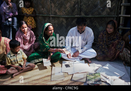 Un uomo dalla Grameen Bank è la raccolta di denaro da donne Foto Stock