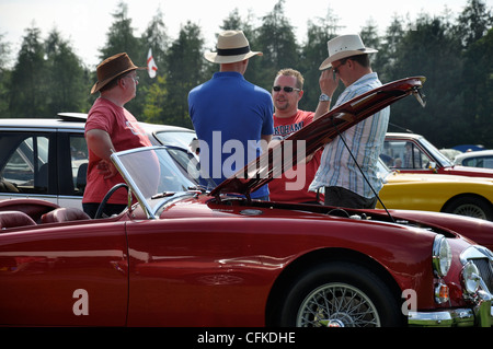 Tatton Park Classic Car Show 2011; 4 uomini a parlare davanti a MGA rosso con cofano aperto. Foto Stock