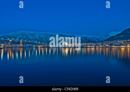 Vista da Tromso in Norvegia attraverso il mare di Norvegia guardando verso Tromso Eismeerkathedrale al centro dell'immagine. Foto Stock