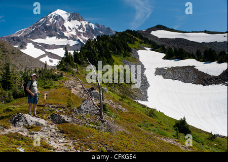 Escursionista in McNeil crinale di Monte Cofano vulcano. Glisan ghiacciaio e Ladd Glacier sopra. Cattedrale cresta (L) Yocum cresta (R). Monte Cofano, Oregon Foto Stock