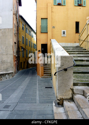 Scale, street e edifici di colore arancione con persiane verdi nella città vecchia di Mentone, a sud della Francia Foto Stock