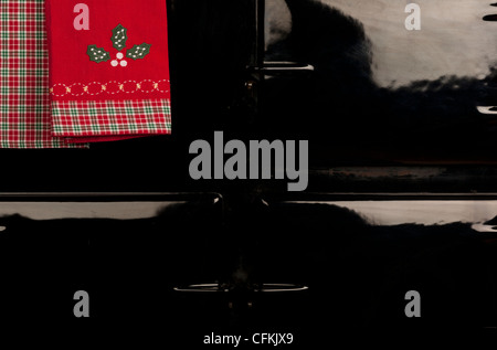 Holly motif asciugamano appeso alla rotaia di un Aga piano di cottura Foto Stock