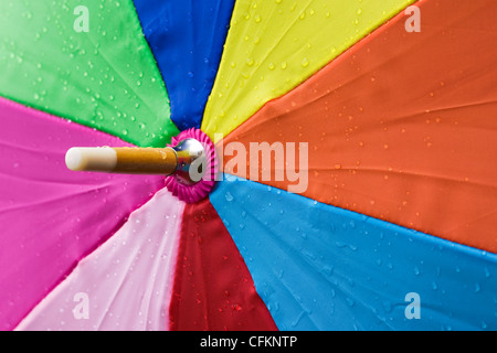 Close up di un ombrello multicolore sotto la pioggia. Foto Stock