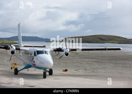 Un Flybe Twin Otter si prepara a prendere il via dalla spiaggia pista sull'Isle of Barra nelle Ebridi Esterne della Scozia. Foto Stock