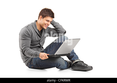 Un maschio sorridente lavorando su un computer portatile isolato su sfondo bianco Foto Stock