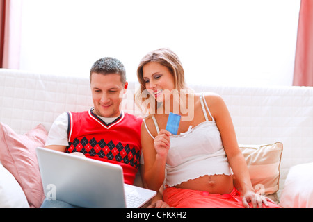 Felice giovane donna incinta con il marito facendo acquisti on-line Foto Stock