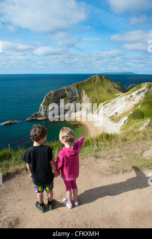 I bambini godere una vacanza a porta di Durdle, West Lulworth, Dorset, Regno Unito Foto Stock