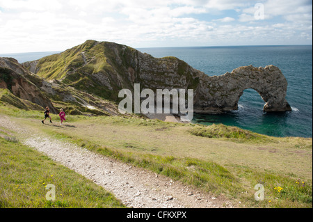 I bambini godere una vacanza a porta di Durdle, West Lulworth, Dorset, Regno Unito Foto Stock