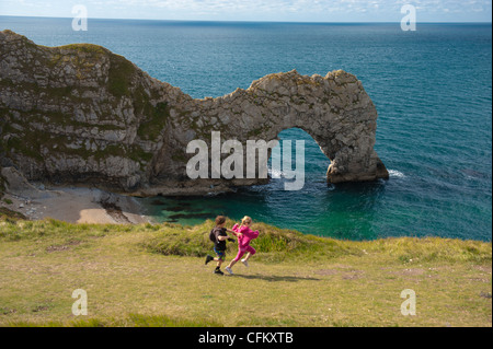 I bambini godere una vacanza a porta di Durdle, West Lulworth, Dorset, Regno Unito Foto Stock