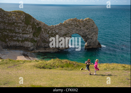 I bambini godere una vacanza a porta di Durdle, West Lulworth, Dorset, Regno Unito Foto Stock