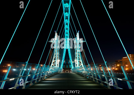 Salford Quays Millennium footbridge stretching over il Manchester Ship Canal di notte. Foto Stock