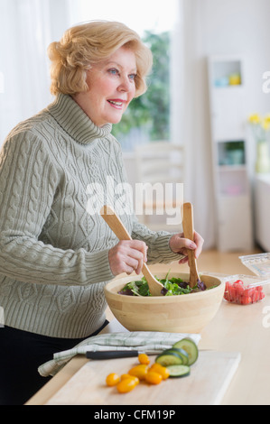Stati Uniti d'America, New Jersey, Jersey City, Senior donna insalata di preparazione Foto Stock