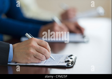 Città di Jersey, New Jersey, Close up di uomo di mani di riempimento sotto forma di applicazione Foto Stock