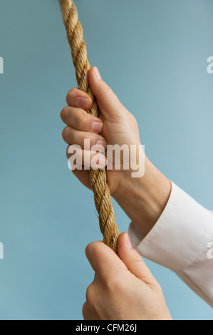 In prossimità delle mani dell'uomo tirando la corda, studio shot Foto Stock