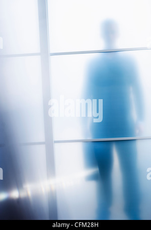 Stati Uniti d'America, New Jersey, Jersey City, sagome di imprenditore dietro la porta di vetro Foto Stock