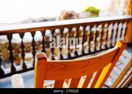 Da dietro il legno vuota la sedia a dondolo, ringhiera di balcone vista a Mohonk Mountain House di New Paltz, New York, Stati Uniti d'America 2012 Foto Stock