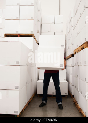 Stati Uniti, California, Santa Ana, lavoratore scatole porta in magazzino Foto Stock