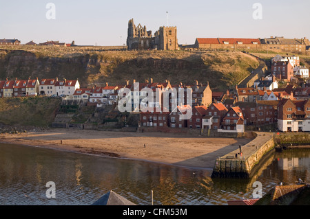 Vista sul porto di inferiore a Whitby Abbey & St Mary's Church, East Cliff, casolari tradizionali di seguito, Whitby, North Yorkshire, Regno Unito Foto Stock