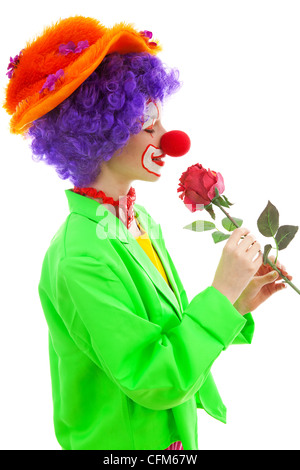 Ritratto di bambino vestito come colorata divertente clown odore di rose rosso su sfondo bianco Foto Stock