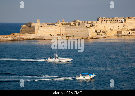 Fort Ricasoli da Valletta, con barca e taxi d'acqua che passa, Malta, Mediterraneo, Europa Foto Stock