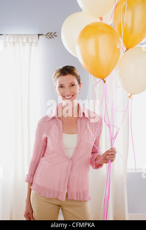 Stati Uniti, California, Los Angeles, Donna in rosa camicetta palloncini di contenimento Foto Stock