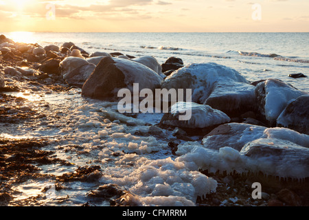 Rocce congelate a costa del mar Baltico di Fehmarn al tramonto Foto Stock