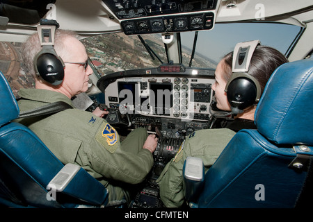 BASE AEREA DI YOKOTA, Giappone -- (da sinistra a destra) il Colon. Otto Feather, 374th comandante dell'ala dell'ascensore aereo, e il Capt. Christina Lee, 5th Air Force, volano sopra la base aerea di Yokota, Giappone in un Huron C-12 durante il suo volo finale, 15 marzo 2012. Noti come il "volo fini", gli aviatori militari hanno una tradizione in cui, dopo il completamento del loro volo finale, i membri dell'equipaggio vengono incontrati e inziditi con acqua dai loro compagni di squadrone, famiglia e amici. Foto Stock