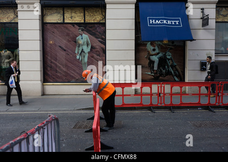 Operaio edile al di fuori del mens' abbigliamento outfitters Hackett in Philpot Lane in London Square Mile. Foto Stock
