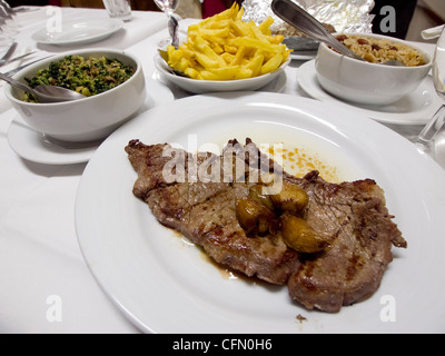 Bistecca alla griglia con aglio, patatine fritte, migas e riso Foto Stock