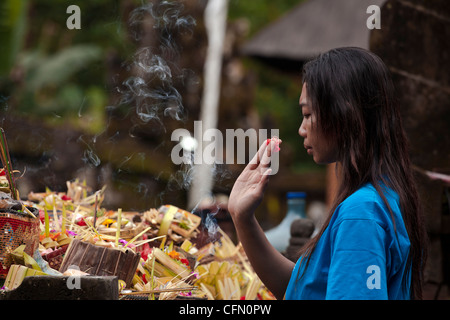 Ragazza pregando con offerte a una cerimonia religiosa in Bali, Pacifico del Sud, Indonesia, Asia sud-orientale, Asia. Foto Stock