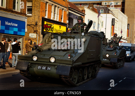 Truppe in veicoli blindati guidare passato High Street negozi durante un Yeomanry Royal Parade Foto Stock