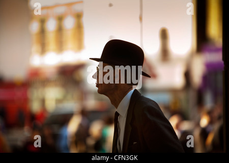 Spettatore in un cappello bowler guardando le truppe nella parata di Hammersmith Foto Stock