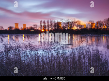Torri di raffreddamento a opere chimiche riflessa nel lago ghiacciato (Charlton's Pond) in Billingham, North East England, Regno Unito Foto Stock