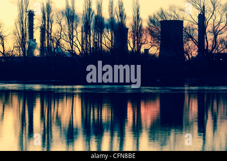 Torri di raffreddamento a opere chimiche riflessa nel lago ghiacciato (Charlton's Pond) in Billingham, North East England, Regno Unito Foto Stock