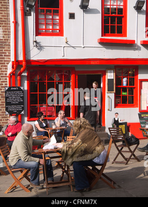 Turisti che si godono una sosta e ristoro presso i tavoli fuori Arnie's Bistro Café in luogo di mercato Whitby North Yorkshire Foto Stock