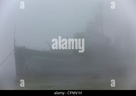 Mattinata nebbiosa sul Tamigi, l'HMS Belfast è avvolta nella nebbia Foto Stock