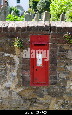 Red post scatola incassata in una parete di pietra che confinano con un cimitero in Rye Foto Stock