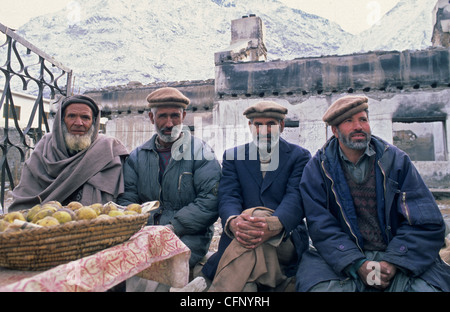 Uomini pakistani seduta in strada della città di Gilgit nella valle di Hunza, Pakistan. Foto Stock