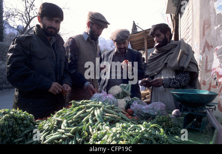 Il pakistan uomini stavano in piedi intorno a un mercato ortofrutticolo in Gilgit, Hunza Valley, Pakistan. Foto Stock