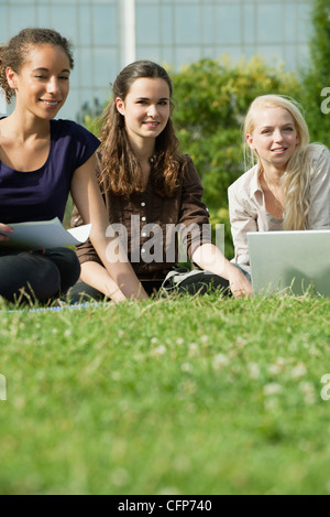 Femmina gli studenti universitari che studiano insieme su erba, basso angolo di visione Foto Stock