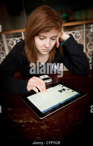 Una ragazza adolescente utilizzando un Apple nuovo iPad3 Computer tablet, UK, aggiornando il suo stato di Facebook Foto Stock