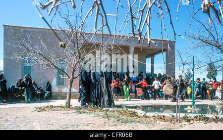 IRAN, ARAK: North American le donne e gli uomini iraniani in ballo di nozze in Iran rurale mentre velata donne iraniane guardare. Archival Foto Stock